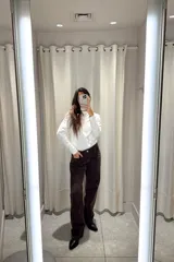 Pantalón de jean corte wide leg color marrón oscuro, con tiro medio y cierre frontal con botón metálico.