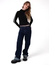 Pantalón de jean color azul oscuro con corte relajado, diseño de cinco bolsillos, cierre de cremallera y botón, y puños enrollados en la parte inferior de las piernas.