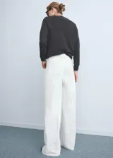 Pantalón de jean tiro alto con diseño wideleg, confeccionado en algodón. Presenta bolsillos de parche en la parte delantera, bolsillos traseros, trabillas para cinturón y cierre frontal con botón y cremallera.