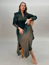 Vestido largo verde con efecto degradado, mangas largas abullonadas y falda con tajos laterales.