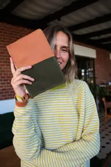 Sobre de cuero y gamuza color camel y verde oliva con cierre de cremallera y correa de muñeca extraíble.