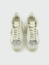 Zapatillas de caña media estilo deportivo, color blanco, con efecto desgastado en la suela. Presentan el logo estrella lateral cubierto de purpurina plateada y detalles perforados en el cuero. Llevan cordones blancos y la inscripción "GGDB MID/STAR" en el lateral.