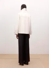 Pantalón de vestir color marrón oscuro, de corte recto y holgado, con tiro medio y diseño clásico de pernera ancha.