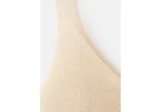 Top musculosa de punto color dorado con brillo, escote en V y tirantes finos.