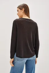 Remera de manga larga color negro, con detalle de encaje en la parte superior delantera y hombros. Presenta un corte holgado y fluido.