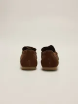 Mocasines de gamuza color tostado, de punta fina y diseño clásico, con detalle de antifaz en el empeine con el logo de la marca grabado.