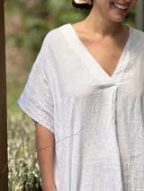 Vestido largo de lino color azul marino, con escote en V y mangas cortas amplias. Presenta un corte relajado y bolsillos laterales.