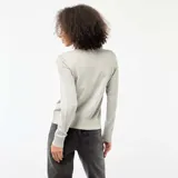 Cárdigan de punto fino en color gris, con cuello redondo y cierre frontal de botones a tono. Presenta mangas largas con puños ajustados y un diseño entallado.