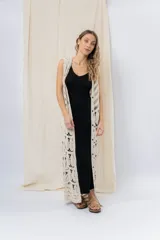 Chaleco largo tejido en punto calado color beige, de silueta recta y caída fluida. Presenta un diseño artesanal con transparencias sutiles que aportan textura y movimiento.
