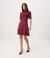 Vestido midi evasé color bordó, con cuello alto, mangas cortas y cintura marcada con cinturón fino removible con hebilla metálica dorada.