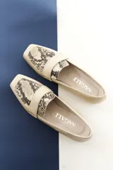 Mocasines de cuero vacuno color beige con textura efecto cocodrilo, punta cuadrada y taco bajo.