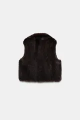 Chaleco de cuello solapa y manga sisa, confeccionado en tejido sintético efecto pelo de color bordó. Cuenta con bolsillos de vivo en el delantero y cierre frontal con ganchos metálicos ocultos.