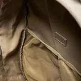 Mochila deportiva color verde oliva, confeccionada en material textil con acabado arrugado. Cuenta con compartimento principal amplio, bolsillo frontal con cierre, compartimento inferior independiente para calzado y tirantes ergonómicos ajustables. Incluye logo circular de la marca en el frente.