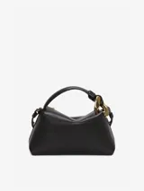 Bolso negro de cuero con asa corta y correa bandolera desmontable. Presenta un eslabón de cadena dorado y cierre de cremallera.