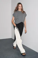 Chaleco oversize de lana color gris, con cuello redondo, manga sisa y bajo asimétrico con aberturas laterales.