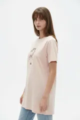 Remera de algodón blanca, de corte holgado, con cuello redondo y diseño estampado en el centro que incluye un gato comiendo de un plato y la inscripción 'Wild Cats'.