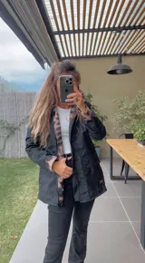 Campera negra con capucha, cierre frontal con cremallera y bolsillos laterales. Interior con forro de animal print.