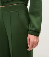 Pantalón deportivo Get Over de corte recto y color verde militar, confeccionado en mezcla de viscosa, poliéster y elastano. Cuenta con cintura ancha de sastrería y frisos o pliegues frontales.
