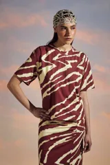 Remera de algodón flameado con estampado de cebra en color rojo y crema, de corte recto y mangas cortas.