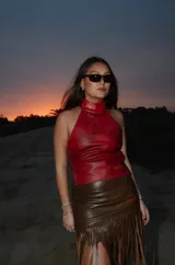 Top halter de cuero rojo con efecto marmolado, espalda descubierta y tiras ajustables cruzadas en la espalda.