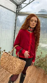 Saco de punto de algodón con cuello redondo y cierre frontal de botones multicolor. Presenta un diseño de bloques de color con cuerpo en rojo y detalles en contraste en el cuello, puños y ruedo.