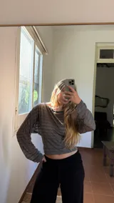 Blusa de jersey rayado con diseño de hombros caídos, mangas largas amplias y cintura ajustada.