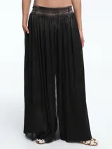 Pantalón de corte amplio y tiro medio, confeccionado en una base de algodón con una capa de tul negro superpuesta que aporta volumen y movimiento, simulando una falda larga.