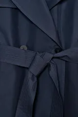 Trench oversize de Zara Woman Collection, color azul marino, confeccionado en hilatura con mezcla de algodón. Presenta cuello solapa, manga larga ajustable con trabillas, bolsillos delanteros y cinturón del mismo tejido con lazadas. Destacan los pespuntes marcados a tono y el cierre frontal cruzado con botones.