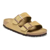 Sandalia Birkenstock modelo Arizona de dos correas ajustables con hebillas metálicas. Presenta una capellada de gamuza en color crema, plantilla anatómica de corcho y suela de goma antideslizante.