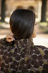 Vestido corto de lino con estampado floral en tonos tierra, verde y marrón. Presenta cuello redondo, mangas tres cuartos con volumen y silueta holgada.