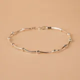 Pulsera semirrígida de plata 925, compuesta por una cadena fina con pequeñas esferas intercaladas a lo largo de toda la pieza.