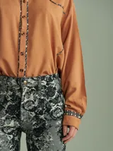 Camisa negra de algodón con mangas largas, cuello camisero y detalles de ribetes estampados a cuadros en los hombros, puños y aberturas de botones.