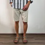 Bermuda de gabardina color marrón claro, corte recto, con bolsillos laterales y traseros.