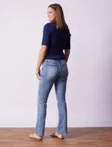 Jean de corte recto, color azul lavado, con cierre frontal y botón metálico. Presenta bolsillos funcionales en la parte delantera y trasera, con costuras reforzadas y pasadores para cinturón en la cintura.