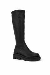 Bota de caña alta color negro con acabado texturado y suela chunky de goma con plataforma dentada.