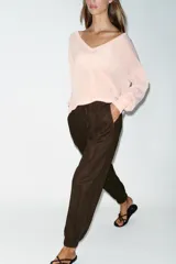 Pantalón jogger de tiro bajo color marrón, con cintura elástica ajustable con cordón, bolsillos delanteros y puños elásticos en los tobillos.