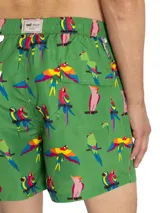 Short de baño de secado rápido con estampado de guacamayos sobre fondo verde. Cuenta con cintura elástica, cordón ajustable, bolsillos laterales y bolsillo trasero.