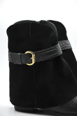 Bota corta de diseño sofisticado que combina texturas. Presenta puntera en cuero grabado tipo croco y caña en gamuza suave. Incluye una correa decorativa con hebilla metálica en el tobillo y taco bajo.