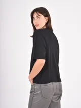 Remera de algodón color negro, con cuello redondo, corte holgado y mangas cortas con dobladillo ancho.