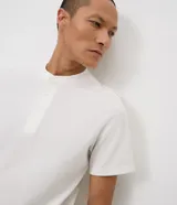 Remera masculina Marfinno de corte slim, confeccionada en tejido de piqué con textura. Presenta cuello redondo estilo Henley con abertura delantera de tres botones y mangas cortas.