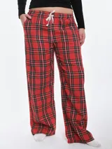 Pantalón de dormir de franela de algodón con estampado de cuadros escoceses en tonos rojos, negros y blancos. Presenta un corte recto y holgado, cintura elástica con cordón ajustable y bolsillos laterales.