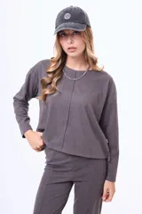 Buzo de felpa color beige con cuello redondo, mangas largas y costura central vertical en el frente.