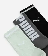 Kit de tres pares de medias deportivas Puma de caña larga. Un par es beige con dos rayas marrones y logo de Puma. Otro par es blanco liso. El tercer par es marrón oscuro con dos rayas blancas y logo de Puma. Todas están confeccionadas en algodón.