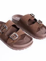 Sandalia de plataforma color marrón, con dos tiras anchas ajustables mediante hebillas metálicas y detalle de tachas plateadas.
