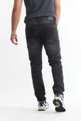 Pantalón de jean azul de corte slim, tiro alto y largo hasta el tobillo.