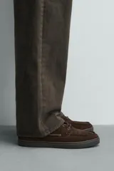 Mocasines estilo náutico de piel con acabado serraje, en color tostado, con cordones y suela de goma a contraste.