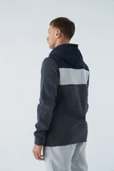 Buzo canguro de felpa color borgoña, con capucha ajustable con cordones color beige, bolsillo tipo canguro y logo estampado en el pecho. Tiene una franja horizontal blanca en el pecho y puños y cintura acanalados.