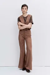 Pantalon de gamuza sintética color marrón, de corte recto y tiro alto, con detalles bordados en la parte frontal.