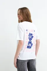 Remera celeste de manga corta con estampa en la espalda de flores y la leyenda "Summer Surf Sessions".