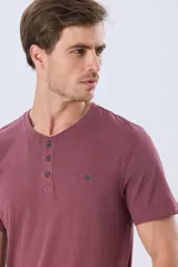 Remera básica de manga corta y cuello redondo, color bordó, con cartera de botones en el pecho y pequeño bordado al tono.